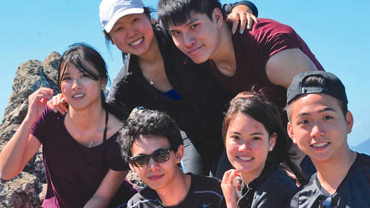 Aurélie Chong (coiffée d’une casquette) posant  fièrement avec ses amis au sommet de la montagne.