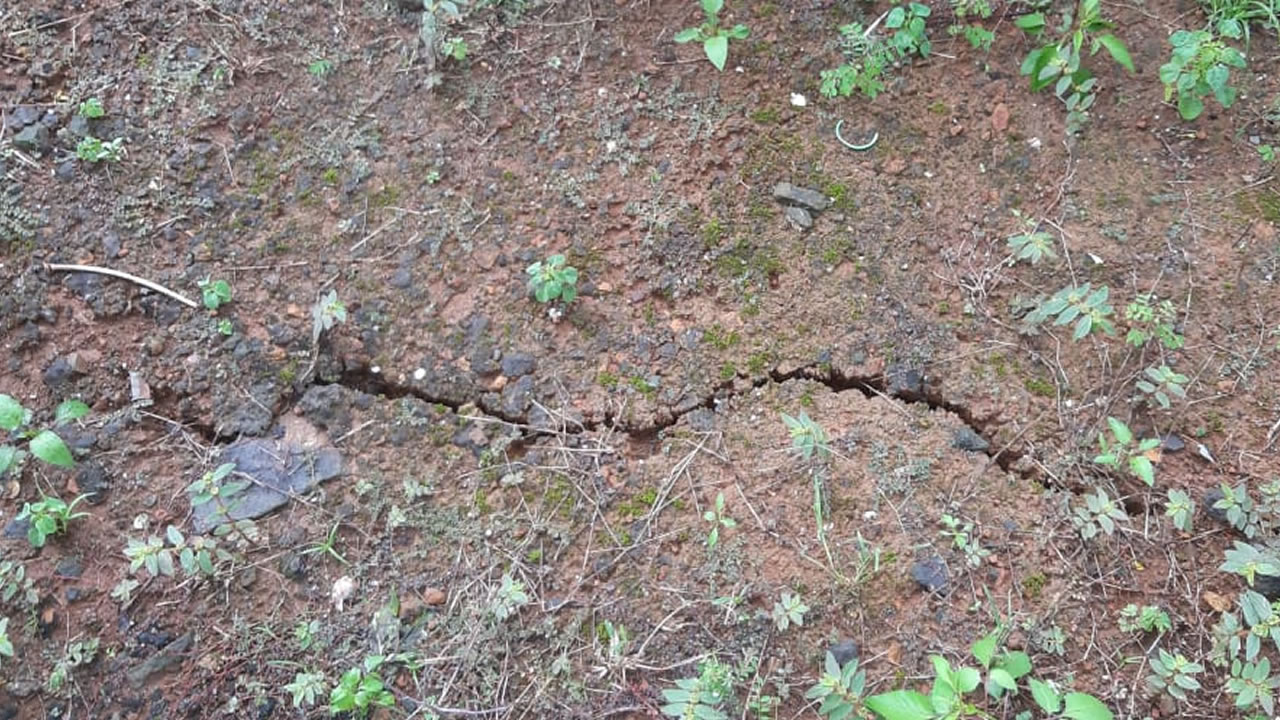 Les fissures sont visibles sur le sol et les structures en béton dans la cour.