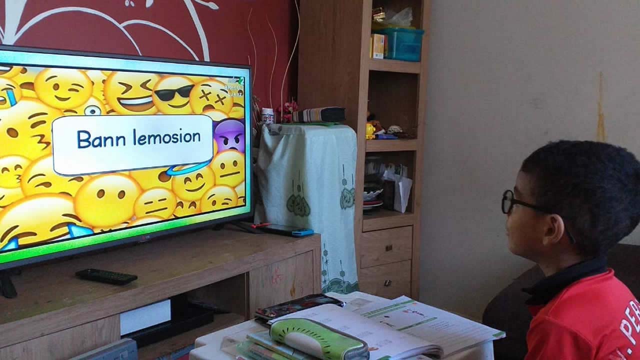 Un écolier devant la télévision pour les cours télévisés.