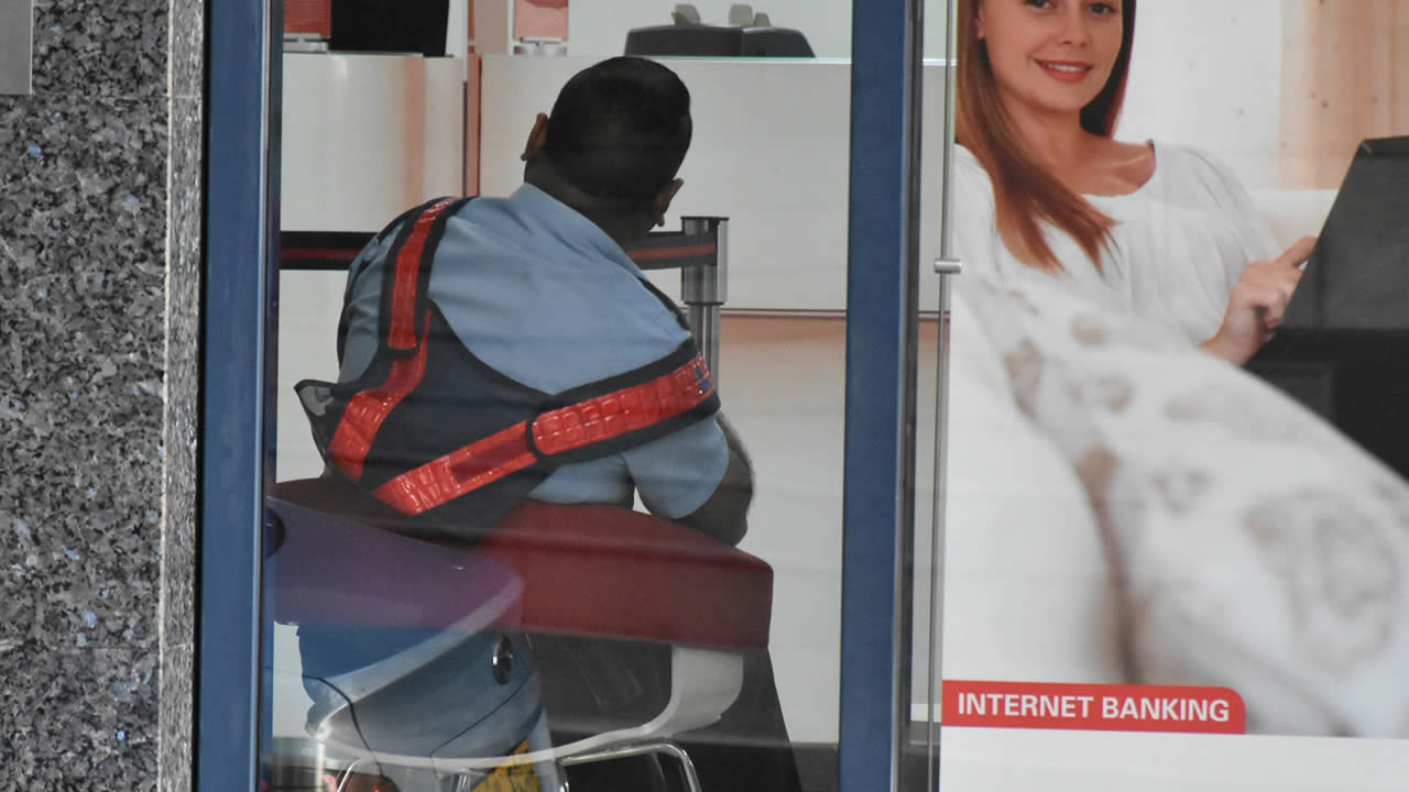 Le policier s’asseyant confortablement sans son couvre-chef sur son lieu  de travail.