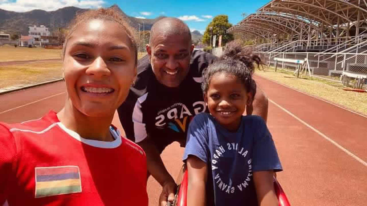 Kiara à son entraînement de course en fauteuil aux côtés de la vice-championne du monde du 100 m (catégorie T54) Noemi Alphone et de son coach, Jean-Marie Bhugeerathee.