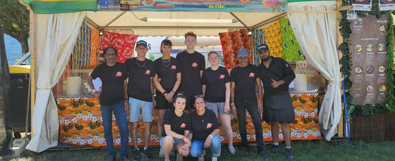 Midyaan Ghoorbin (à l'extrême droite, debout), aux côtés de son père Fehzal Ghoorbin, et de ses employés lors d'un festival.